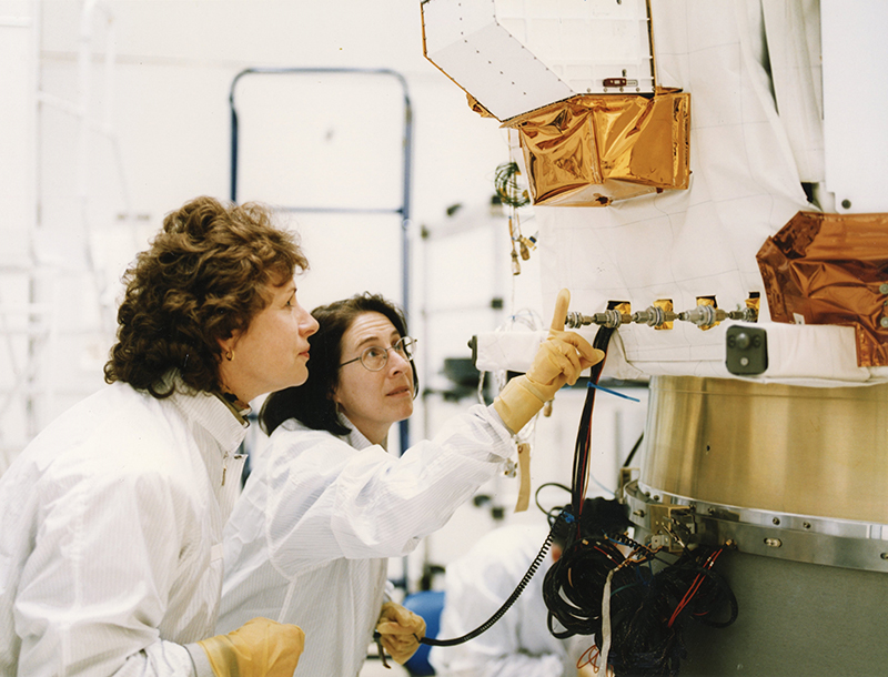 Mary Chiu (right) and spacecraft systems engineer Judy von Mehlem check out a fill valve for the ACE propulsion subsystem