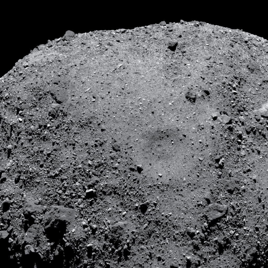 Image of asteroid Bennu showing impact crater and resulting landslide
