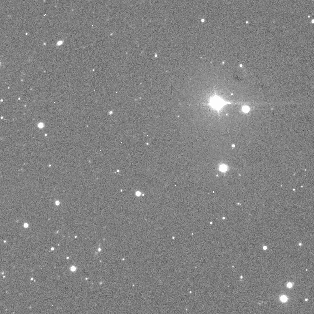 A black-and-white gif of a star field with the small Didymos system moving through the frame