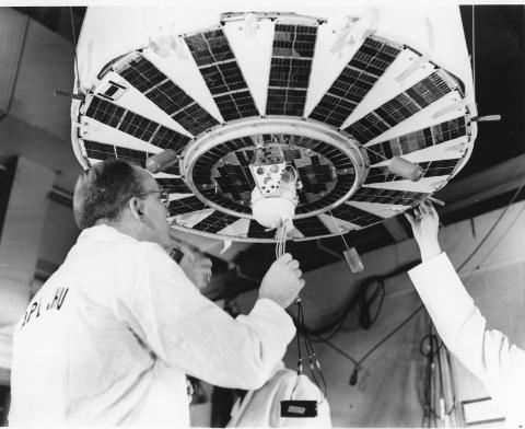 A man inspects the small capsule holding Transit-4A's plutonium power source