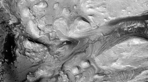 A black and white image of Mars surface where showing salt deposits on a mountain